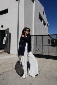 LA blogger Tania Sarin in designers remix white wide leg pants and goyard tote.
